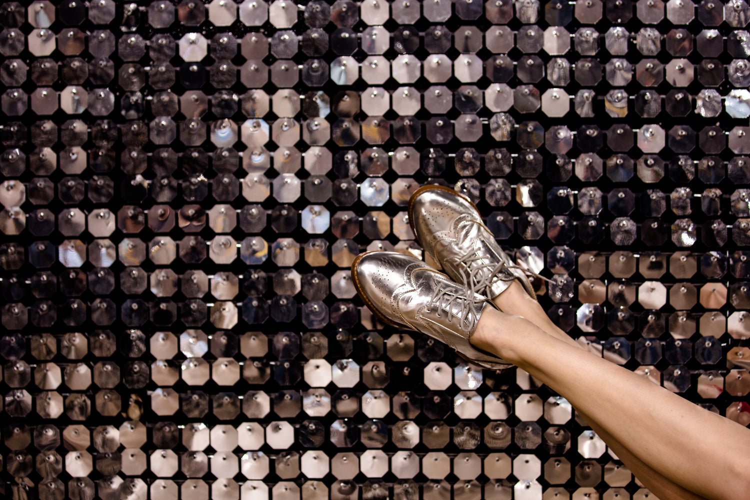 silver wingtip shoes on silver background